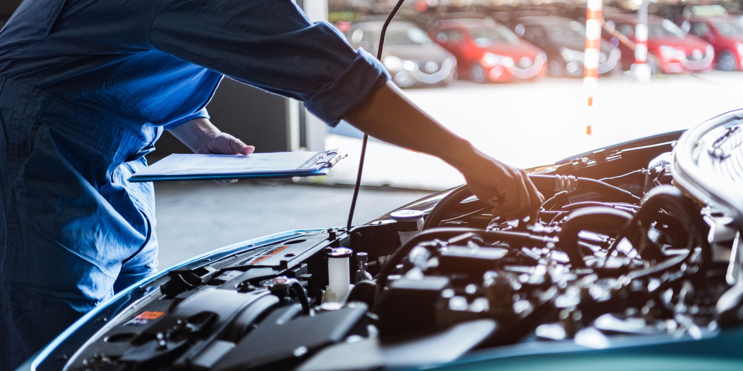 Automotive Parts: Car mechanic holding clipboard and checking to maintenance vehicle by customer claim order in auto repair shop garage. Engine repair service. People occupation and business job. Automobile technician